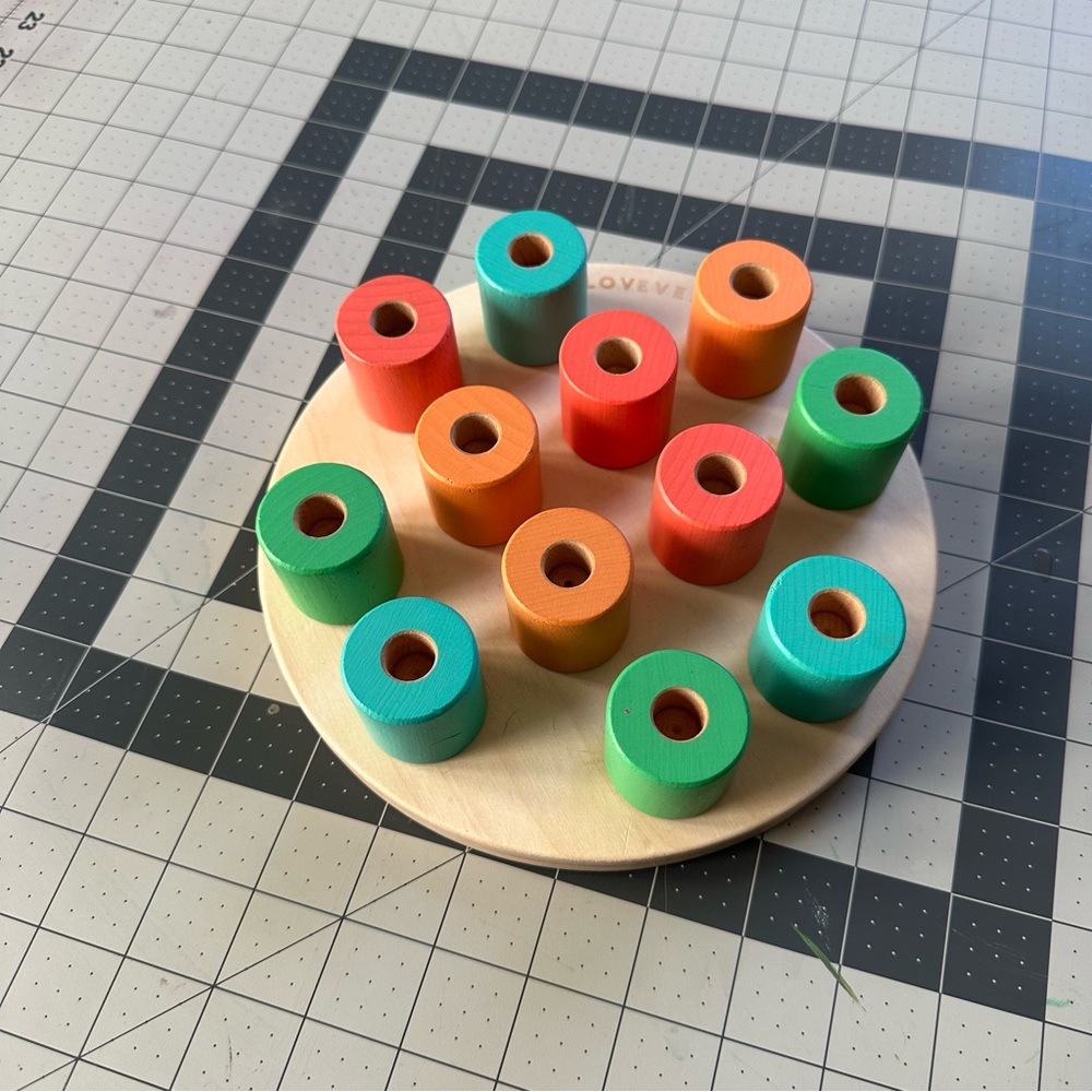 Lovevery wooden stacking Montessori pegboard toy.
